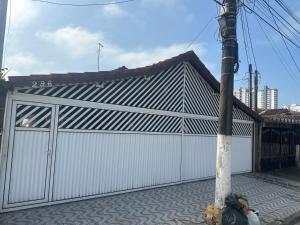 um edifício com uma garagem branca com um poste em Casa de praia com piscina em Solemar