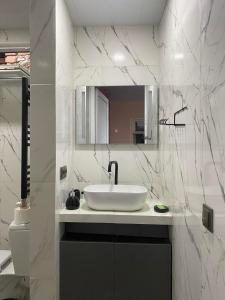 a white bathroom with a sink and a mirror at guest house Telavi XXI in Tʼelavi