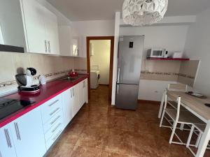 een keuken met witte kasten en rode aanrechtbladen bij Melo Home Vecindario-Near AirPort-Elevator-Garage in Sardina