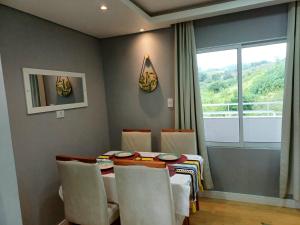 ItapevyMinicasa Show, 27m², com churrasqueira e varanda!的一间有桌子、椅子和窗户的餐厅