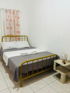 Bett mit gelbem Rahmen in einem Zimmer in der Unterkunft Elle's House in Dipolog City