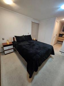 - une chambre avec un grand lit noir dans l'établissement Estancia Perfecta en Los Andes, à Los Andes
