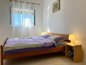 um quarto com uma cama, uma janela e um candeeiro em Ivan 4+2 em Pakoštane