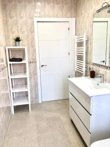 ein Badezimmer mit einer weißen Tür und einem Waschbecken in der Unterkunft Recién reformado, céntrico, tranquilo y luminoso in Oviedo