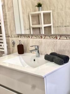 een badkamer met een wastafel en een spiegel bij Recién reformado, céntrico, tranquilo y luminoso in Oviedo