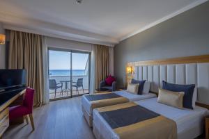 a hotel room with two beds and a view of the ocean at Sunland Resort Beldibi in Beldibi