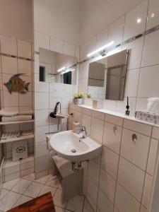 uma casa de banho branca com um lavatório e um espelho em Have a nice home em Leipzig