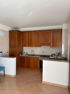 eine Küche mit Holzschränken und einer Arbeitsplatte in der Unterkunft Casa vacanze Bella Vista in Campomarino