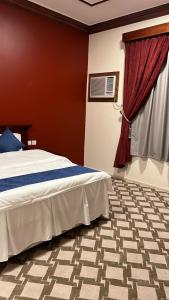 a bedroom with a bed and a window at منازل القمه للشقق المخدومه in Tabuk