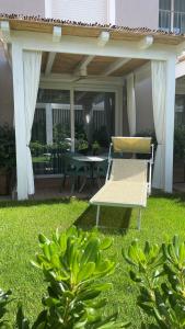 a patio with a table and a chair on the grass at Ancora Resort in Acciaroli