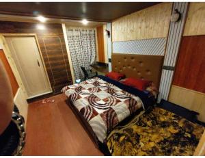 Hotel The Gulmarg Gateway Resort, Jammu and Kashmir في Tangmarg: غرفة نوم صغيرة مع سرير في غرفة