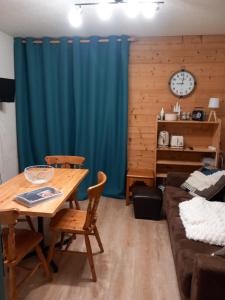 ein Esszimmer mit einem Tisch und einem Sofa in der Unterkunft Joli studio à St Gervais les bains in Saint-Gervais-les-Bains