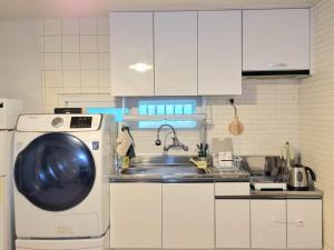 a kitchen with a sink and a washing machine at Healing Stay in Seoul