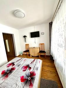 Un dormitorio con una cama con flores rojas. en Casa D'ANA en Geoagiu Băi