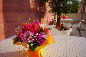 un mazzo di fiori seduto sopra un tavolo di Apartments Residence Dj a Petrovac na Moru