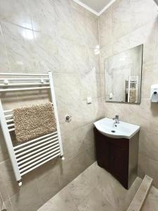 ein Bad mit einem Waschbecken und einem Spiegel in der Unterkunft Casa D'ANA in Geoagiu-Băi