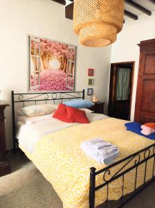 una camera da letto con un letto e un dipinto sul muro di La Casina in Paese a Montepulciano