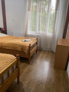a bedroom with two beds and a large window at guest house Telavi XXI in Tʼelavi