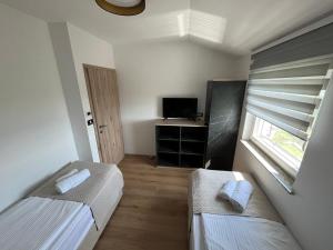 Habitación pequeña con 2 camas y ventana en Villa ELM, en Ankaran