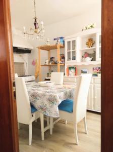 una sala da pranzo con tavolo e sedie bianche di La Casina in Paese a Montepulciano
