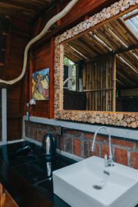a bathroom with a sink and a mirror at Villa Rumah Kayu Lovina in Lovina