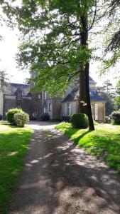 uma árvore em frente a uma casa com uma entrada em Château Saint Georges em Mauléon