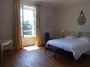 um quarto com uma cama grande e uma janela em Château Saint Georges em Mauléon