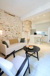 una sala de estar con un sofá y una mesa en La loge des Carmélites Coeur de Nantes WIFI, en Nantes