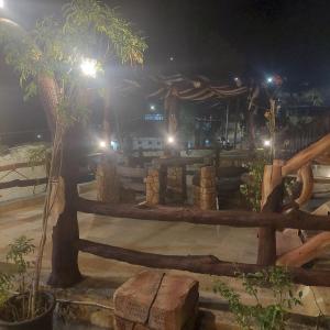 una valla de madera y un árbol por la noche en Dana Gate Lodge, en Dana