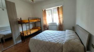 a bedroom with a bed and two bunk beds at La Casa di Anna in Fiumaretta di Ameglia
