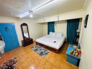 a bedroom with a bed and a mirror and blue doors at Aizawl Hotel in Āīzawl