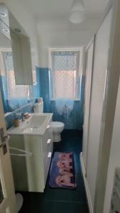 a blue bathroom with a sink and a toilet at La Casa di Anna in Fiumaretta di Ameglia