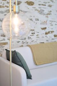 eine Lampe auf einem weißen Sofa mit einem Kissen in der Unterkunft La loge des Carmélites Coeur de Nantes in Nantes