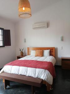 een slaapkamer met een groot bed met een rode en witte deken bij Monte da Pechincha in Estremoz