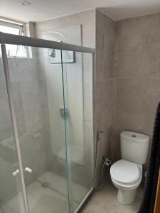 een badkamer met een toilet en een glazen douche bij Bugan Paiva/ Home stay in Recife