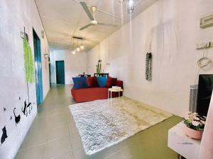 sala de estar con sofá rojo y alfombra en Cozy33#4pax#Wifi#NearAeonAlma#20minstobatukawan, en Bukit Mertajam