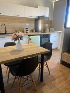 a table with a vase of flowers on it in a kitchen at Joli studio spacieux in Ajaccio +9 photos