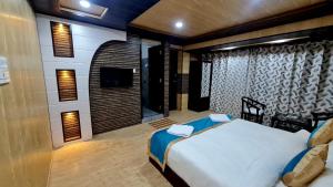 a bedroom with a large bed and a television at HOTEL D INDIAN KARGIL in Kargil