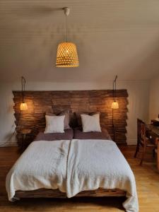 1 dormitorio con 1 cama grande y pared de ladrillo en Bon Chez Nous en Saint-Amand-Jartoudeix
