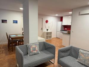 a living room with two couches and a dining room at apartamento luanco playa in Luanco