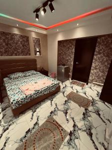 Schlafzimmer mit einem Bett und Marmorboden in der Unterkunft بورتو السخنة in Ain Suchna