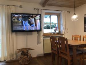 uma televisão pendurada numa parede numa sala de estar em Ferienwohnung Mitteldorf em Oberammergau