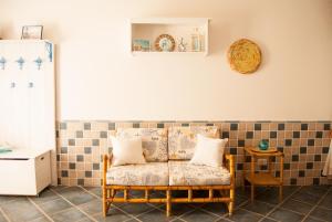 a couch in a room with a tiled wall at Casa Danilo in San Teodoro