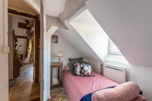 a bedroom with a pink bed in a attic at Maison Jongkind - Garage privé 100 m - Sélection Journée du Patrimoine 2023 in Honfleur