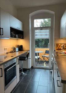 uma cozinha com armários brancos e uma mesa com um pátio em Gästewohnung zum Heiligen Grund em Meissen
