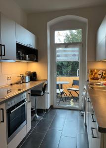 a kitchen with white cabinets and a table with a patio at Gästewohnung zum Heiligen Grund in Meißen
