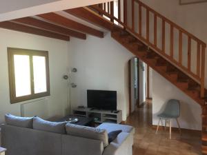 ein Wohnzimmer mit einer Couch und einer Treppe in der Unterkunft Villa CASA CALLISTA , confort et calme in Sainte-Lucie de Porto-Vecchio
