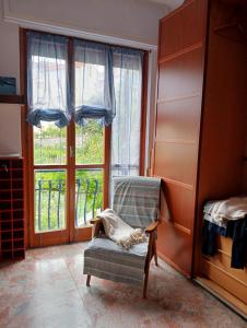 Habitación con silla y ventana grande. en Home Caviglia CITRA 09029-LT-0618, en Finale Ligure