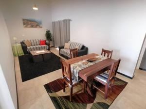 ein Wohnzimmer mit einem Tisch und einem Sofa in der Unterkunft Seashell Haven Hideout in Henties Bay