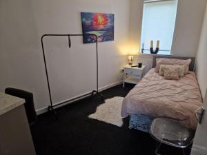 a bedroom with a bed and a lamp in it at The M Rooms at 144 in Kirk of Shotts